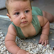 Robin participe au concours pour gagner de l'argent avec cette photo : baby, child, infant, crawling, green_clothing, drool, curious, rock, stones, outdoor, portrait, closeup, hand, face, skin, natural_light, young_child, expression, casual, focus