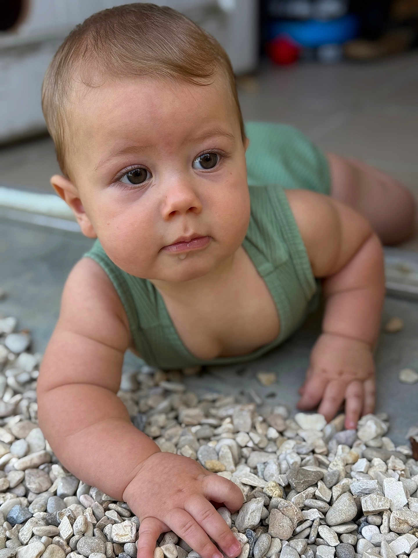 Robin participe au concours pour gagner de l'argent avec cette photo : baby, child, infant, crawling, green_clothing, drool, curious, rock, stones, outdoor, portrait, closeup, hand, face, skin, natural_light, young_child, expression, casual, focus