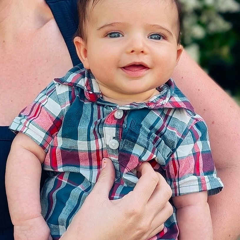 Dante joined the competition — help win amazing prizes! adult_hand, baby, blue_eyes, child, closeup, cute, greenery, happy, holding, infant, nature, outdoor, person, plaid_shirt, portrait, short_sleeves, skin, smiling, summer, young