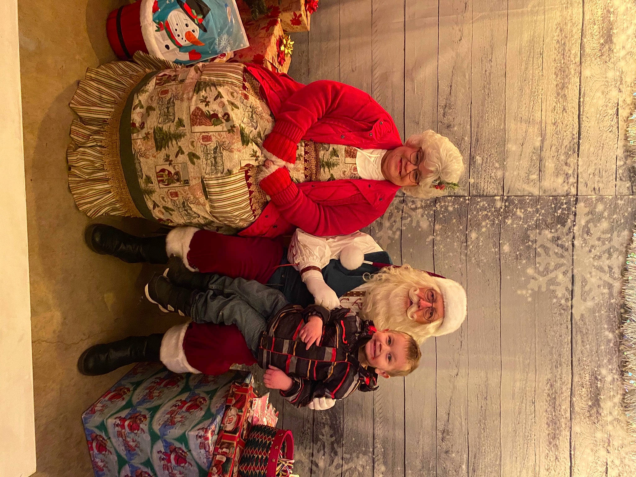 Greyson is registered to the contest to win money with this photo: baby, child, event, fun, happy, hat, headwear, holiday, joy, lap, leisure, person, plant, room, sitting, smile, textile, toddler, tradition, tree