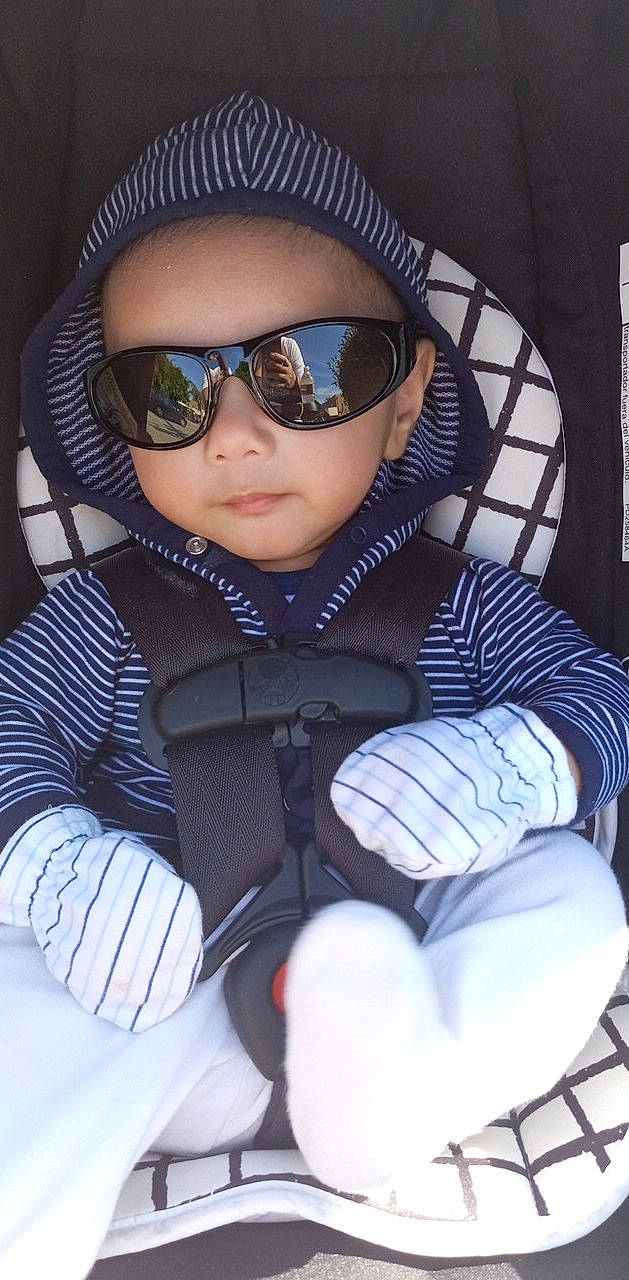 Alexander is registered to the contest to win money with this photo: baby, baby_toddler_clothing, cap, car_seat, comfort, electric_blue, eye_glass_accessory, eyewear, glasses, goggles, headgear, outerwear, person, personal_protective_equipment, sitting, sleeve, street_fashion, sunglasses, toddler, vision_care
