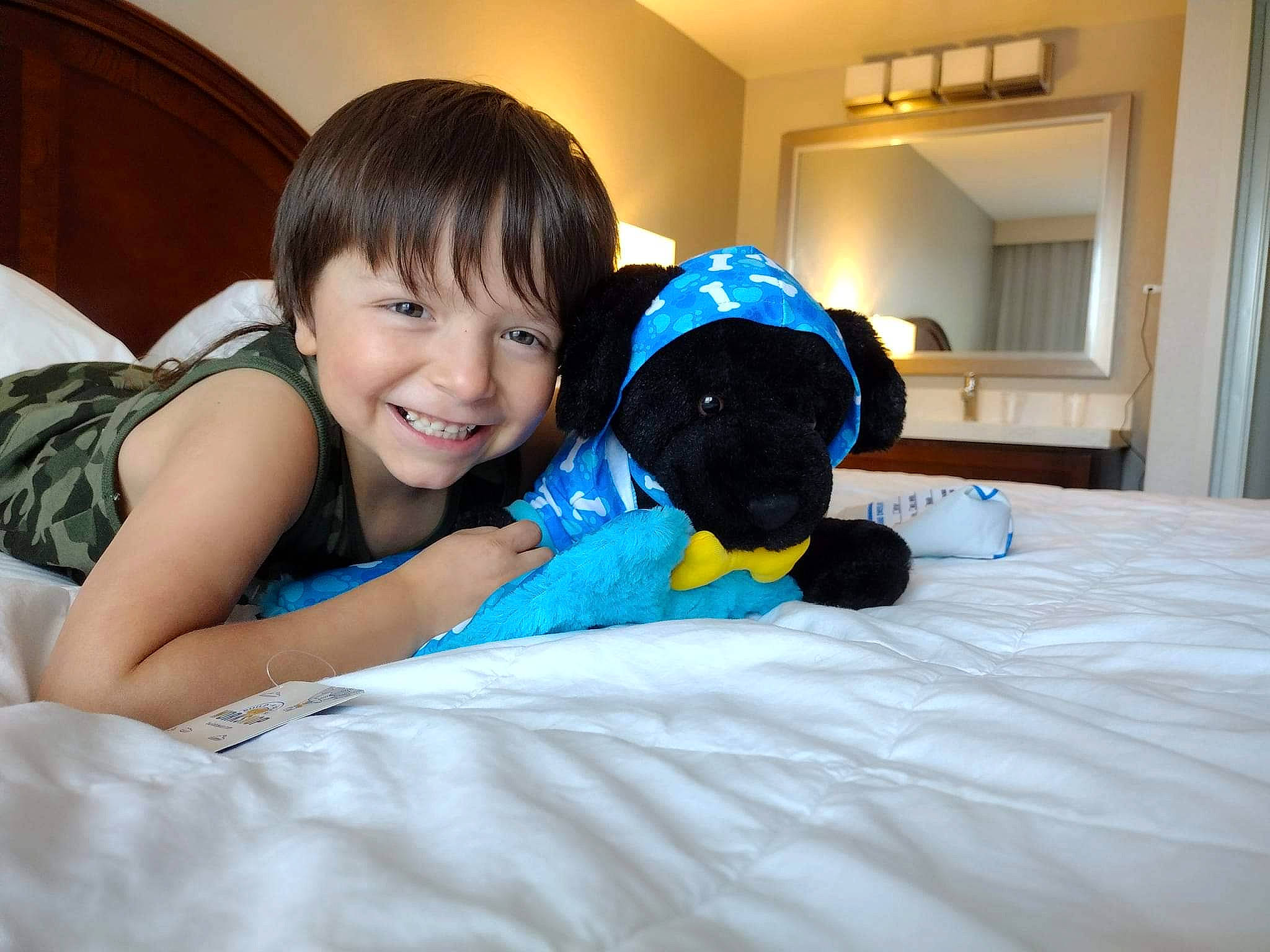 Donovan joined the competition — help win amazing prizes! bed, bedding, child, comfort, couch, flash_photography, fun, happy, human_body, human_leg, joy, leisure, linens, person, room, sitting, smile, t_shirt, teddy_bear, thigh