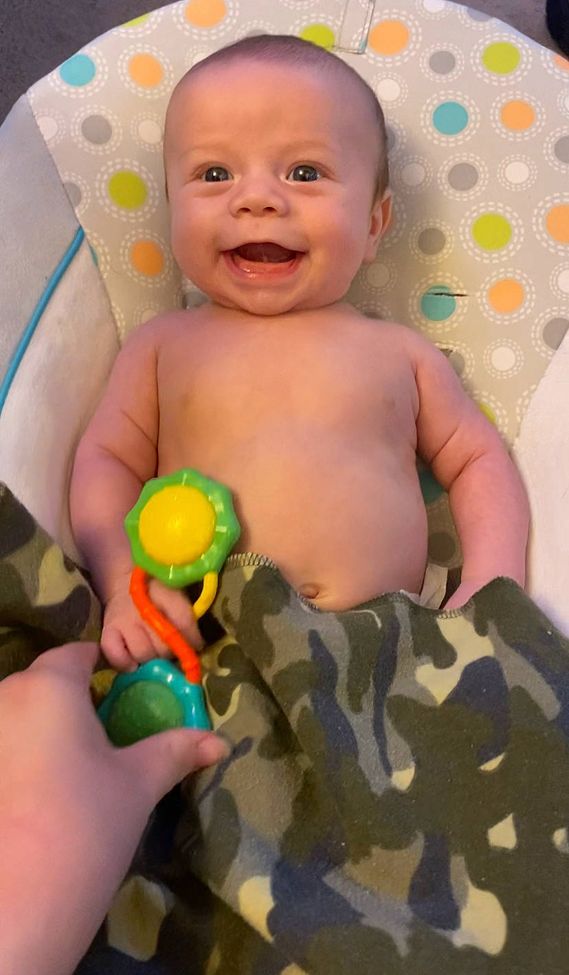 Braxton is registered to the contest to win money with this photo: baby, cheek, child, eye, face, facial_expression, finger, fun, hand, happy, head, iris, joy, nose, organ, person, photograph, pink, product, skin