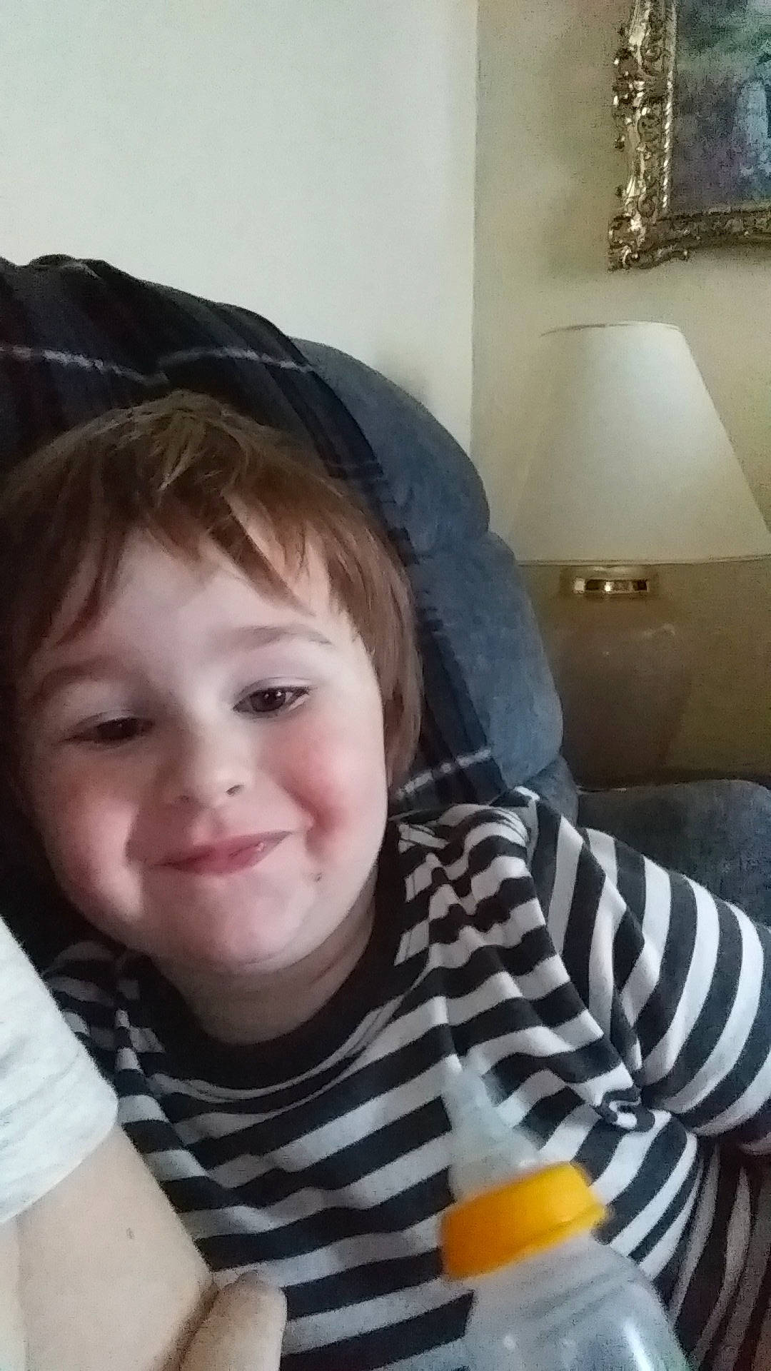 Damien is registered to the contest to win money with this photo: baby_toddler_clothing, cheek, citrus, eye, fruit, iris, joy, juice, lamp, lighting_accessory, mammal, mandarin_orange, nose, orange, orange_drink, orange_juice, person, tangelo, tangerine, toddler