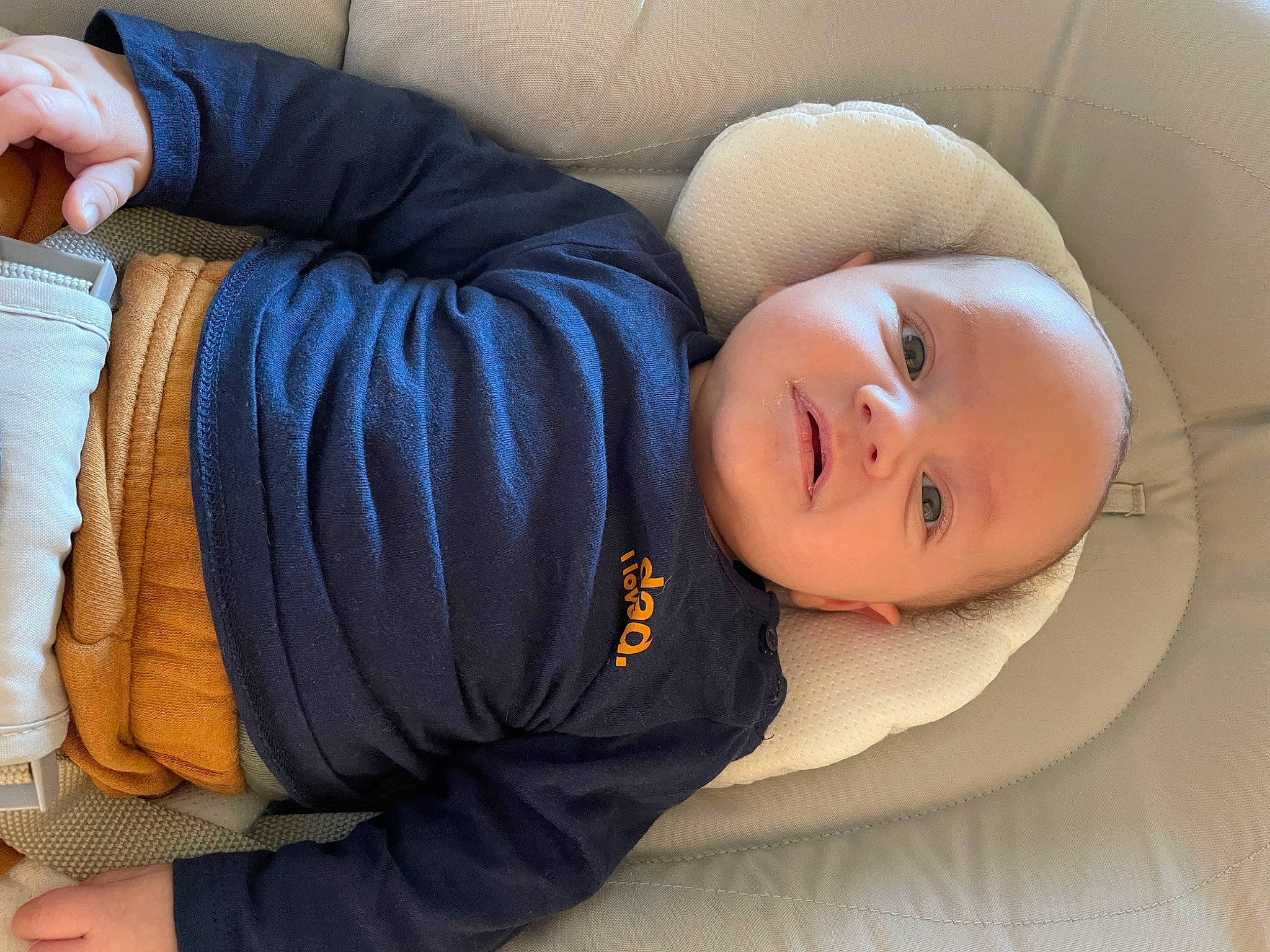 Néo participe au concours pour gagner de l'argent avec cette photo : baby, car_seat, child, comfort, denim, elbow, finger, flooring, gesture, headgear, human_leg, joint, knee, linens, person, sitting, sleeve, smile, textile, thigh