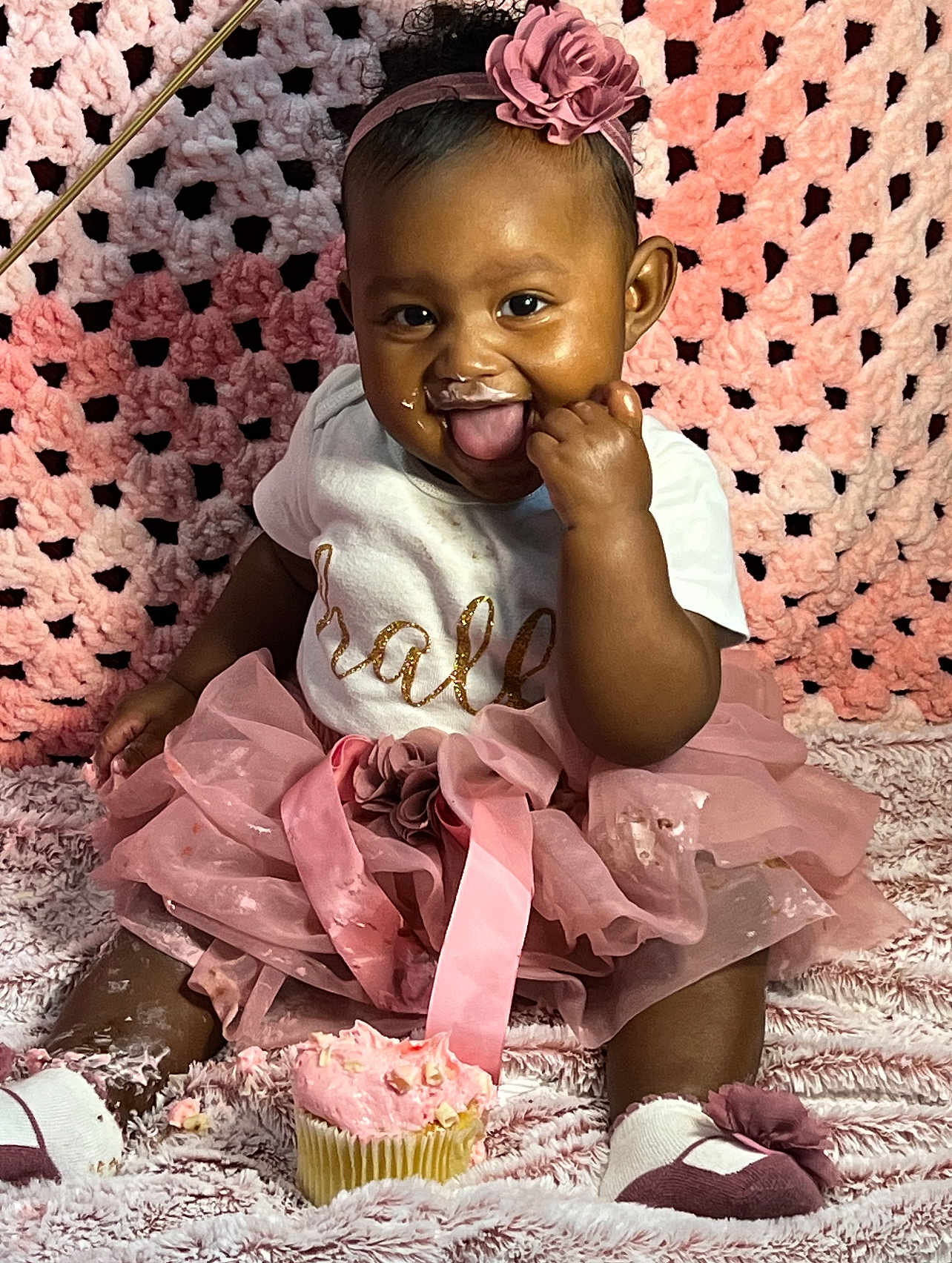 Layelle is registered to the contest to win money with this photo: baby, blanket, celebration, child, clothing, crocheted_backdrop, cupcake, cute, flower, footwear, frosting, girl, happy, headband, pink, portrait, sitting, smiling, tongue_out, tutu