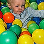 Tommy participe au concours pour gagner de l'argent avec cette photo : ball_pit, blonde_hair, blue_balls, casual_clothing, child, colorful_balls, curious, cute, fun, green_balls, happy, indoor, netting, orange_balls, plastic_balls, play, portrait, toddler, yellow_balls, young_child