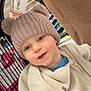 baby, beige_fleece, blue_eyes, child, clothing, cute, face, grocery_store, happy, hat, indoor, knit_hat, person, pom_poms, retail, shopping, shopping_cart, smiling, toddler, warm_clothing