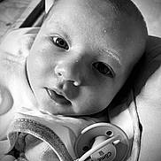 Côme participe au concours pour gagner de l'argent avec cette photo : baby, black_and_white, blanket, child, close_up, clothing, cute, expression, face, head, indoors, infant, lying_down, newborn, pacifier, peaceful, portrait, skin, soft_light, young