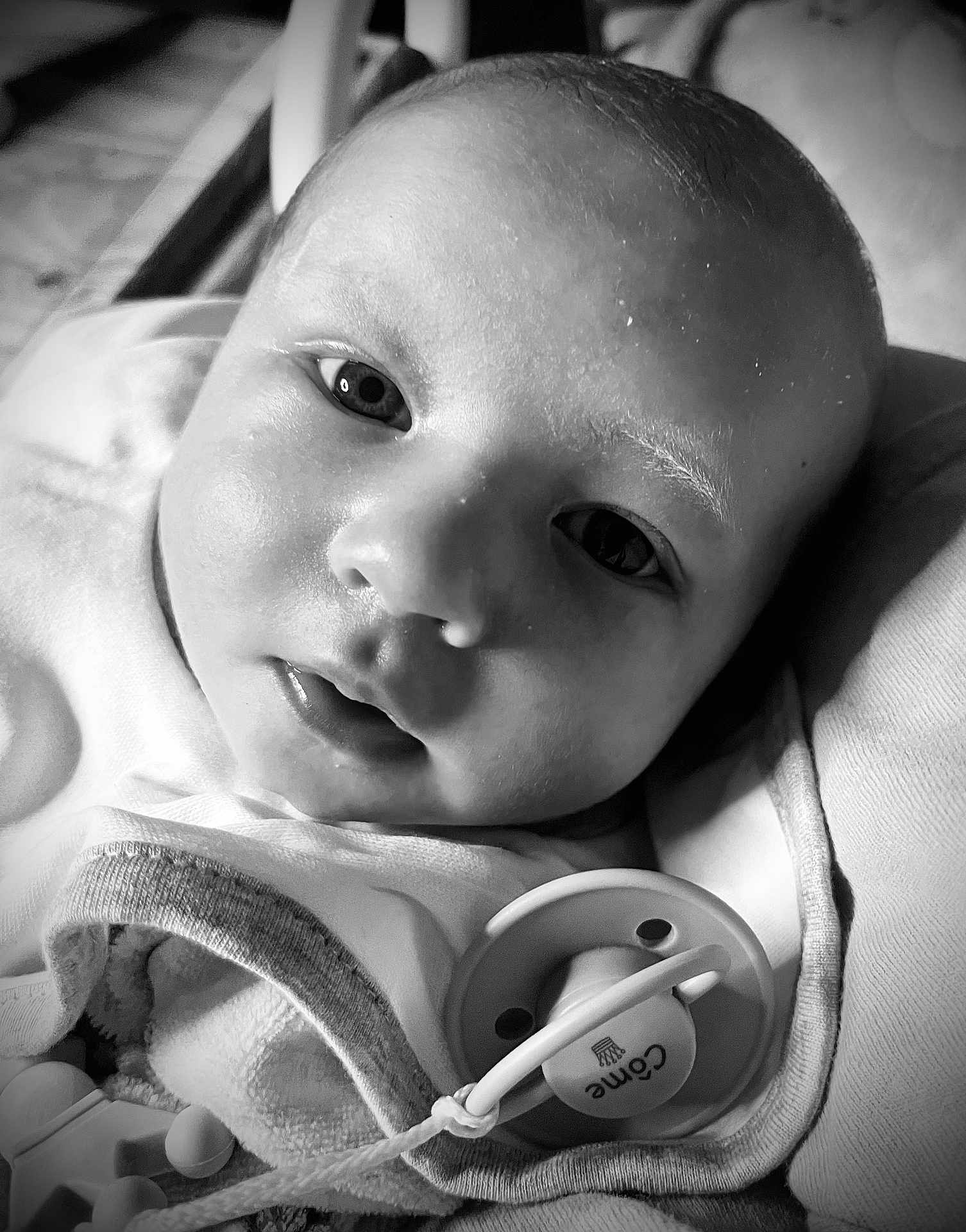 Côme participe au concours pour gagner de l'argent avec cette photo : baby, black_and_white, blanket, child, close_up, clothing, cute, expression, face, head, indoors, infant, lying_down, newborn, pacifier, peaceful, portrait, skin, soft_light, young