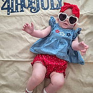 Delaney is registered to the contest to win money with this photo: 4th_of_july, baby, blue, celebration, child, clothing, cute, festive, headband, holiday, independence_day, laying_down, patriotic, red, shorts, socks, striped_socks, sunglasses, text, top