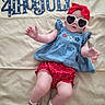 4th_of_july, baby, blue, celebration, child, clothing, cute, festive, headband, holiday, independence_day, laying_down, patriotic, red, shorts, socks, striped_socks, sunglasses, text, top