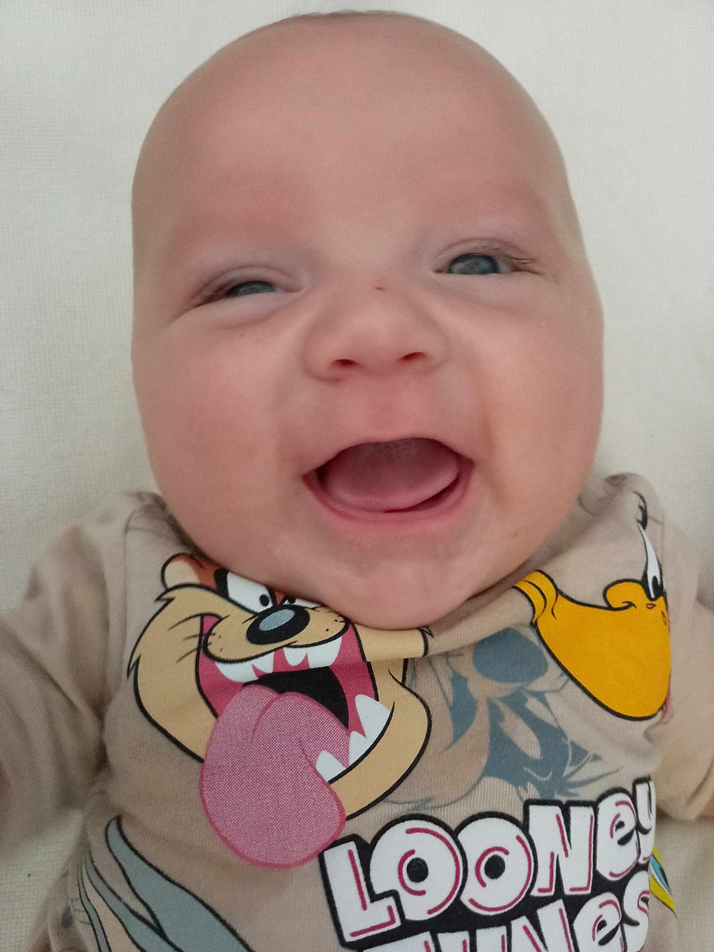 Thomas is registered to the contest to win money with this photo: baby, child, smiling, face, head, clothing, looney_tunes, cartoon, tongue, open_mouth, happy, cute, infant, portrait, tshirt, person, closeup, skin, young, joyful