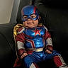 baby, child, costume, superhero, mask, cape, blue, red, gold, smile, chair, leather, indoor, portrait, cute, funny, sitting, happy, young, person