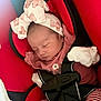 Veniza Snow is registered to the contest to win money with this photo: baby, sleeping, car_seat, headband, bow, red, striped_pants, gloves, infant, child, seatbelt, closeup, indoors, cute, peaceful, young_child, portrait, resting, clothing, baby_girl