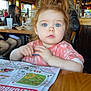 activity_sheet, blue_eyes, casual, child, clothing, crayon, curly_hair, face, indoor, lighting, people, placemat, portrait, red_hair, restaurant, seated, table, toddler, woman, wooden_table