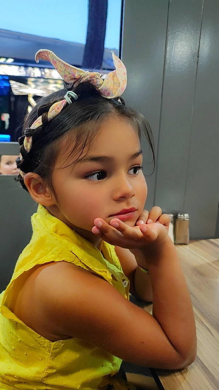 Ayline participe au concours pour gagner de l'argent avec cette photo : audio_equipment, black_hair, cheek, child, chin, clothing, comfort_food, ear, eyebrow, eyelash, fashion_accessory, fun, happy, headphones, hearing, neck, nose, person, skin, tableware