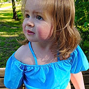 Charlea is registered to the contest to win money with this photo: child, toddler, girl, blue_top, outdoor, bench, greenery, sunlight, portrait, curly_hair, ponytail, nature, summer, casual_clothing, expression, daylight, face, young_child, standing, park
