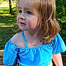 child, toddler, girl, blue_top, outdoor, bench, greenery, sunlight, portrait, curly_hair, ponytail, nature, summer, casual_clothing, expression, daylight, face, young_child, standing, park