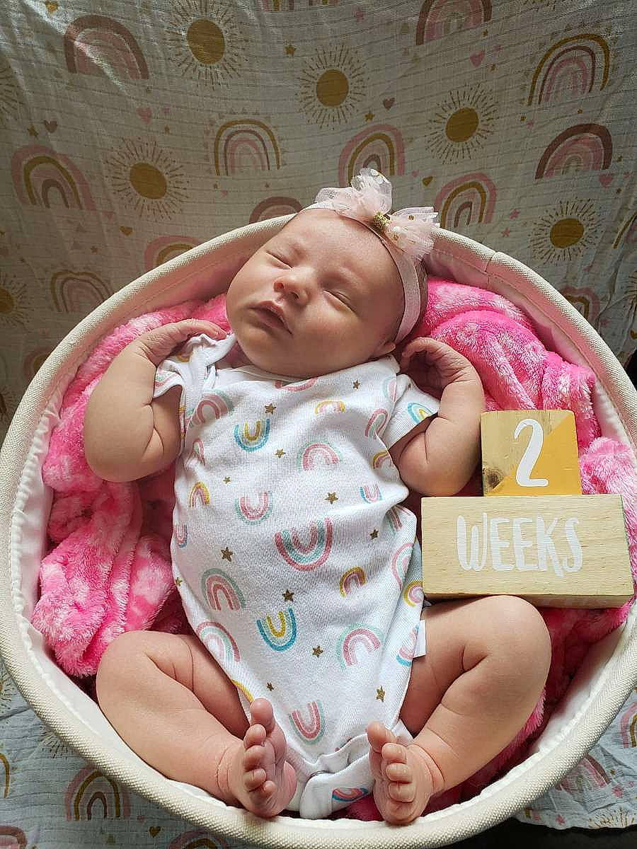 Lana is registered to the contest to win money with this photo: baby, baby_products, baby_safety, baby_sleeping, baby_toddler_clothing, cheek, child, comfort, eye, facial_expression, happy, head, infant_bed, linens, person, pink, room, sitting, skin, sleeve
