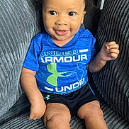 Yahson Mayberry joined the competition — help win amazing prizes! toddler, child, smiling, curly_hair, blue_shirt, under_armour, black_shorts, white_socks, couch, gray_couch, indoor, happy, seated, person, young_child, cute, portrait, baby, comfortable, living_room