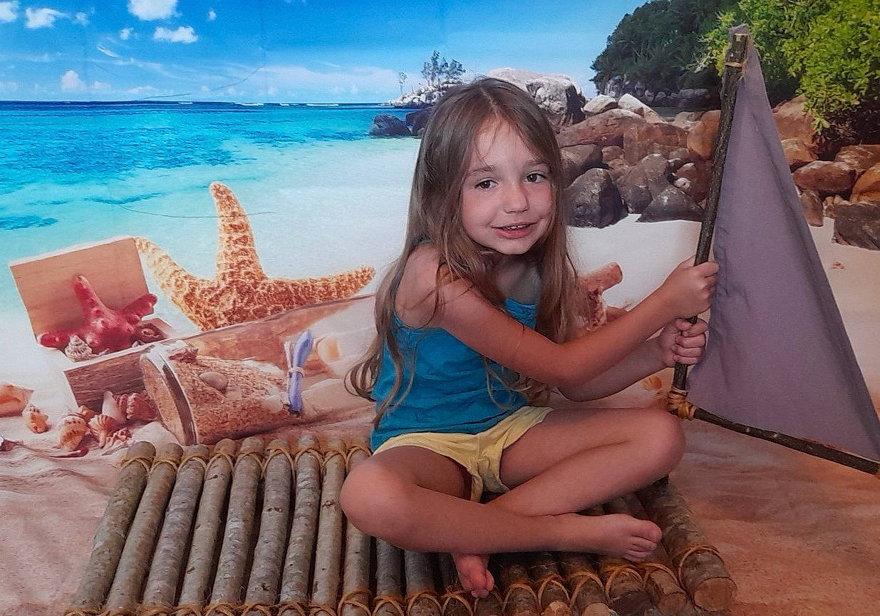 Louna participe au concours pour gagner de l'argent avec cette photo : beach, blue, cloud, foot, fun, hairstyle, happy, human_leg, joy, lap, leg, leisure, long_hair, person, sandal, sky, smile, swimwear, thigh, toddler