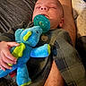 baby, sleeping, pacifier, plush_toy, stuffed_animal, arms, clothing, gray_outfit, bear_emblem, hand, cozy, comfort, indoor, person, infant, cute, child, nap, rest, soft_toy