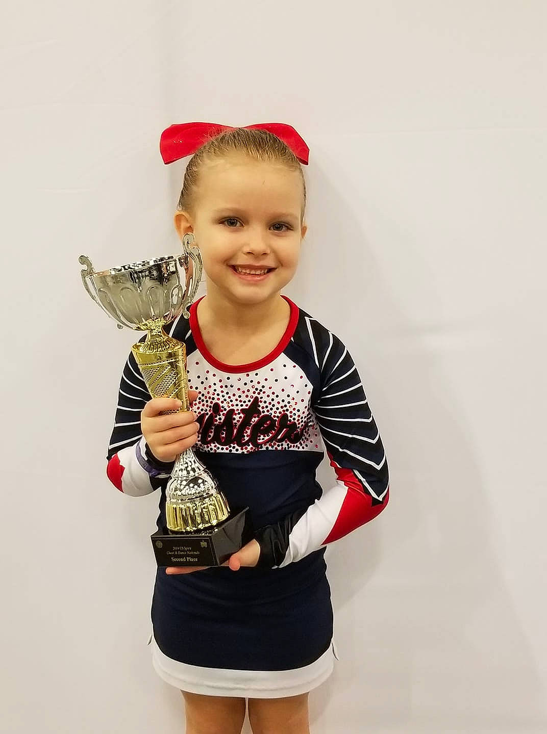 Emrie is registered to the contest to win money with this photo: arm, child, child_model, costume, joy, person, photo_shoot, photography, pigtail, sleeve, sports_uniform, t_shirt, toddler, uniform