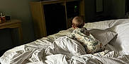 Abel is registered to the contest to win money with this photo: baby, bed, blanket, pajamas, television, animation, room, furniture, carpet, table, mirror, microwave, cabinet, white, sleepwear, indoor, child, watching, cozy, curious