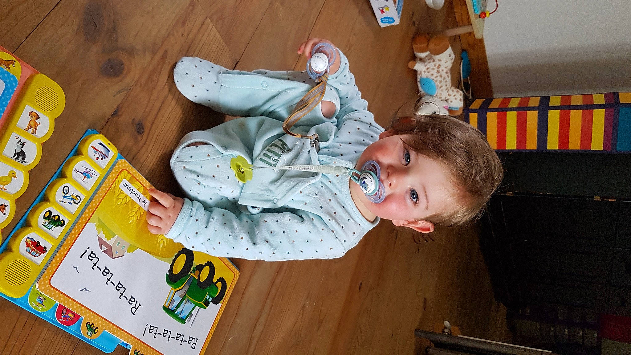 Arsène a rejoint le concours — aidez-le/la à gagner de superbes lots ! baby, baby_toddler_clothing, bookcase, child, flooring, fun, happy, hardwood, leisure, outdoor_shoe, person, play, room, sitting, smile, toddler, walking_shoe, wood