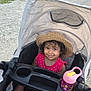 toddler, child, stroller, hat, smile, curly_hair, pink_dress, sippy_cup, outdoor, park, lake, grass, tree, sunny, path, water, nature, happy, baby_shoes, shade
