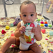 Asy is registered to the contest to win money with this photo: baby, background, child, colorful, cute, expression, face, floor, foot, fruit_pouch, hand, indoor, infant, person, plastic_ball, play_mat, playpen, sitting, toy, white_clothing