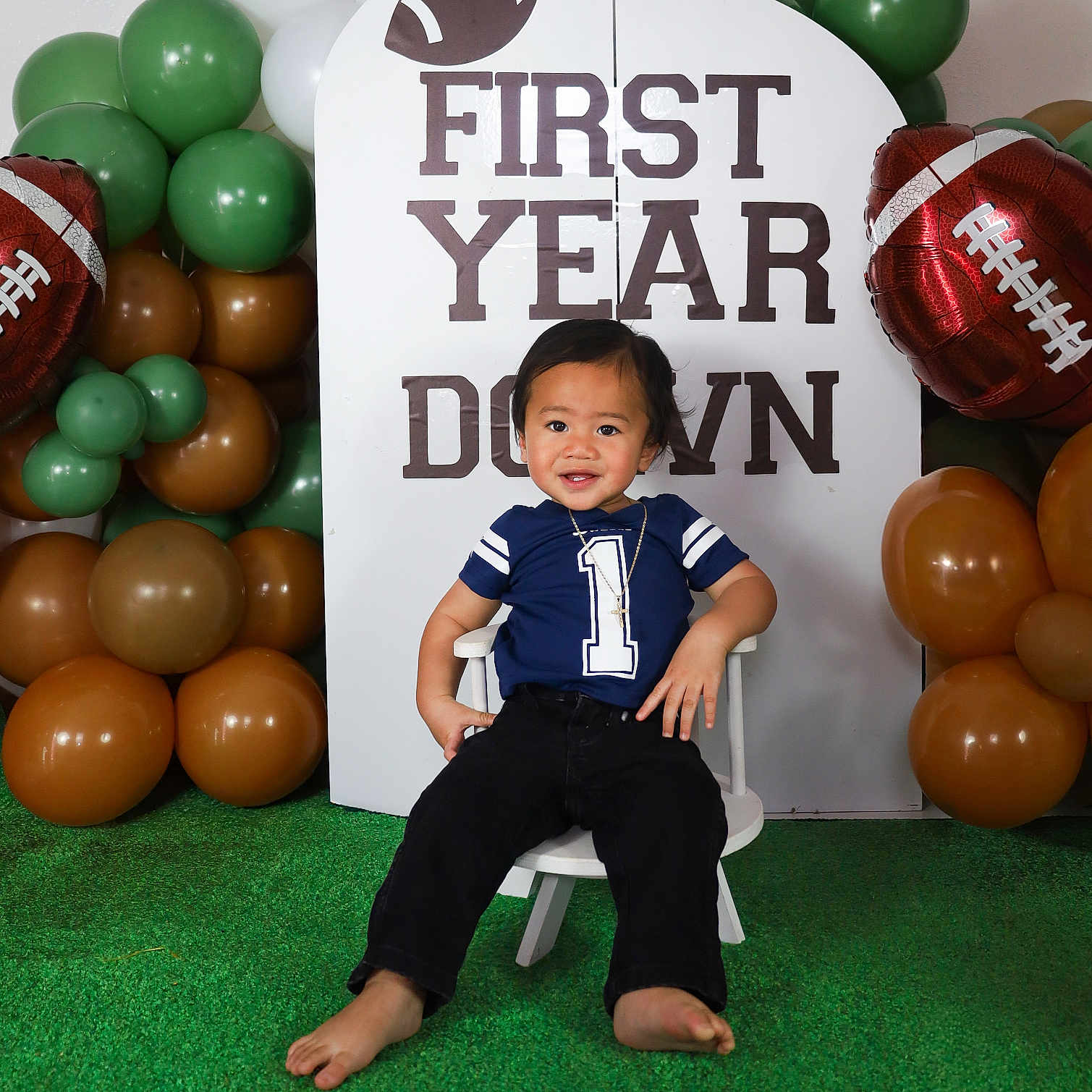 Epoki is registered to the contest to win money with this photo: baby, backdrop, balloons, barefoot, birthday, brown, celebration, chair, child, decorations, first_birthday, football, football_theme, green, indoor, portrait, sitting, smiling, toddler, white