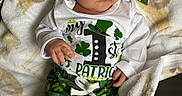 Mateo is registered to the contest to win money with this photo: baby, child, infant, clothing, hat, green, shamrock, st_patricks_day, blanket, white_shirt, pants, sitting, cute, portrait, indoors, face, person, soft_texture, holiday, celebration