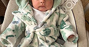 Mateo is registered to the contest to win money with this photo: adorable, baby, carpet, child, clothing, comfortable, cozy, cushioned_seat, cute, dinosaur_hood, expression, hooded_robe, indoor, infant, portrait, seated, socks, soft_texture, warm, young