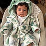 Mateo is registered to the contest to win money with this photo: baby, infant, child, hooded_robe, dinosaur_hood, cushioned_seat, carpet, indoor, cozy, cute, clothing, portrait, socks, soft_texture, seated, expression, young, warm, comfortable, adorable