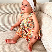 Rose a rejoint le concours — aidez-le/la à gagner de superbes lots ! baby, child, smiling, sitting, couch, dress, headband, flower, happy, indoors, person, skin, foot, hand, furniture, cute, portrait, young, infant, cozy