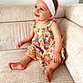 baby, child, smiling, sitting, couch, dress, headband, flower, happy, indoors, person, skin, foot, hand, furniture, cute, portrait, young, infant, cozy