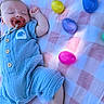 baby, sleeping, blue_onesie, pacifier, blanket, pink, checkered, plastic_eggs, easter_eggs, colorful, infant, outdoor, grass, cute, resting, child, portrait, soft_texture, summer, peaceful