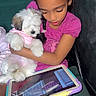 child, dog, puppy, tablet, pink_clothing, pajamas, indoor, cuddling, seated, technology, cute, fluffy, girl, pet, love, cozy, screen, home, closeup, happy