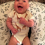 Akira joined the competition — help win amazing prizes! baby, infant, smiling, onesie, giraffe_pattern, pillow, leaf_pattern, leopard_print, happy, cute, child, skin, face, mouth_open, eyes, hand, arm, leg, sitting, indoors