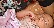 Madison joined the competition — help win amazing prizes! baby, newborn, infant, sleeping, adult, parent, portrait, blanket, pink_blanket, cozy, indoors, lying_down, bed, stars, floral_clothing, dark_clothing, curly_hair, family, resting, closeup