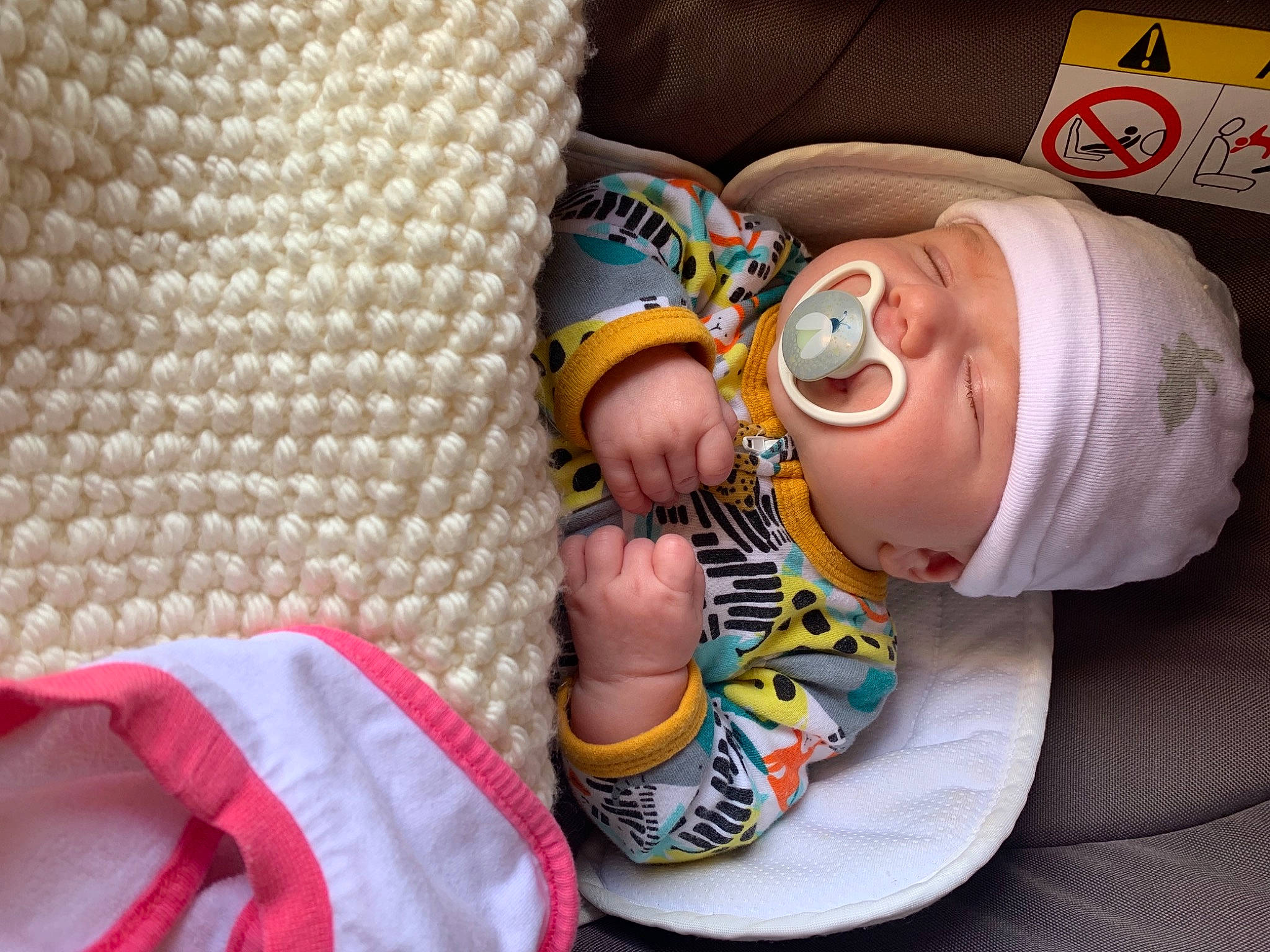 Ambre participe au concours pour gagner de l'argent avec cette photo : baby, baby_products, baby_toddler_clothing, cap, child, comfort, finger, foot, hat, human_leg, linens, nail, pattern, person, personal_protective_equipment, sitting, sleeve, sunglasses, textile, thumb