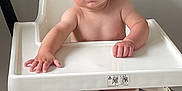 Caius joined the competition — help win amazing prizes! baby, high_chair, child, infant, indoors, curious, expression, face, furniture, vacuum_hose, bare_skin, legs, hands, looking_at_camera, white, plastic, floor, home, person, seated