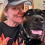 David is registered to the contest to win money with this photo: animal, animal_portrait, black_dog, cap, casual_clothing, closeup, companionship, curtains, dog, face, friendship, happy, human, indoor, pet, portrait, smile, tongue_out, window, woman