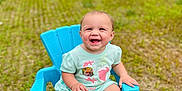 Mackenzie is registered to the contest to win money with this photo: baby, child, smiling, blue_chair, outdoor, grass, green_clothing, happy, infant, sitting, cute, portrait, barefoot, playful, sunny, nature, grass_field, plastic_chair, young_child, daylight