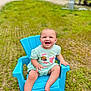 baby, child, smiling, blue_chair, outdoor, grass, green_clothing, happy, infant, sitting, cute, portrait, barefoot, playful, sunny, nature, grass_field, plastic_chair, young_child, daylight