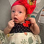 baby, infant, red_bow, blanket, patterned_blanket, polka_dot_clothing, monkey_illustration, baby_clothing, face, hand, indoor, cute, child, portrait, expression, newborn, headband, sitting, curious, wrapped