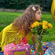 Sara participe au concours pour gagner de l'argent avec cette photo : child, birthday_cake, yellow_dress, flowers, yellow_roses, vase, outdoor, green_grass, birthday_candle, pink_cake, tweety_bird, tablecloth, celebration, party, girl, long_hair, hair_clip, colorful, festive, portrait