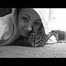 Tigger joined the competition — help win amazing prizes! black_and_white, cat, person, indoor, carpet, hoodie, face, pet, tabby_cat, closeup, lying_down, portrait, animal, cute, relaxed, eyes, companion, cozy, home, calm